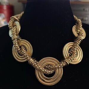 Necklace five golden circles graduated sizes intertwined with a serpentine rope